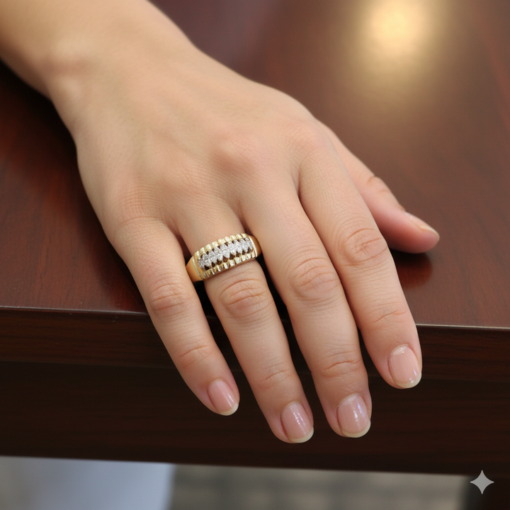 Hand wearing a gold ring with diamonds on a wooden surface