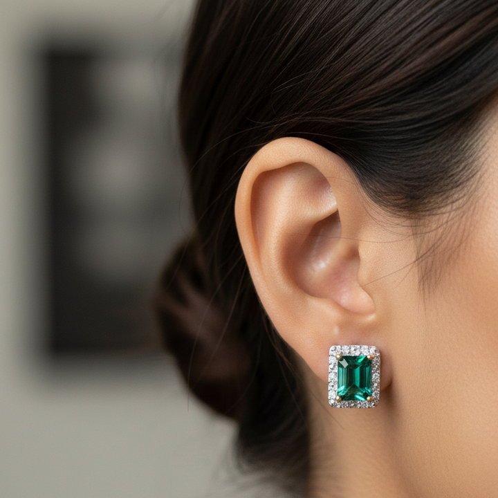 Close-up of a woman wearing a green emerald earring with a blurred background