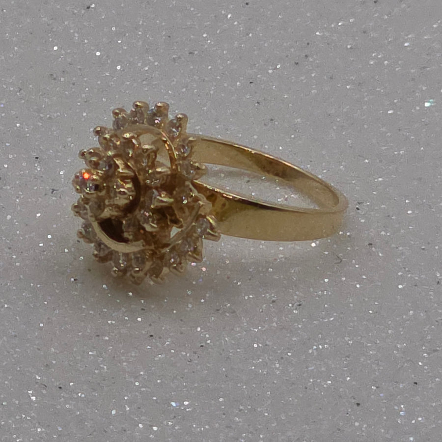 Gold ring with a textured design on a gray background