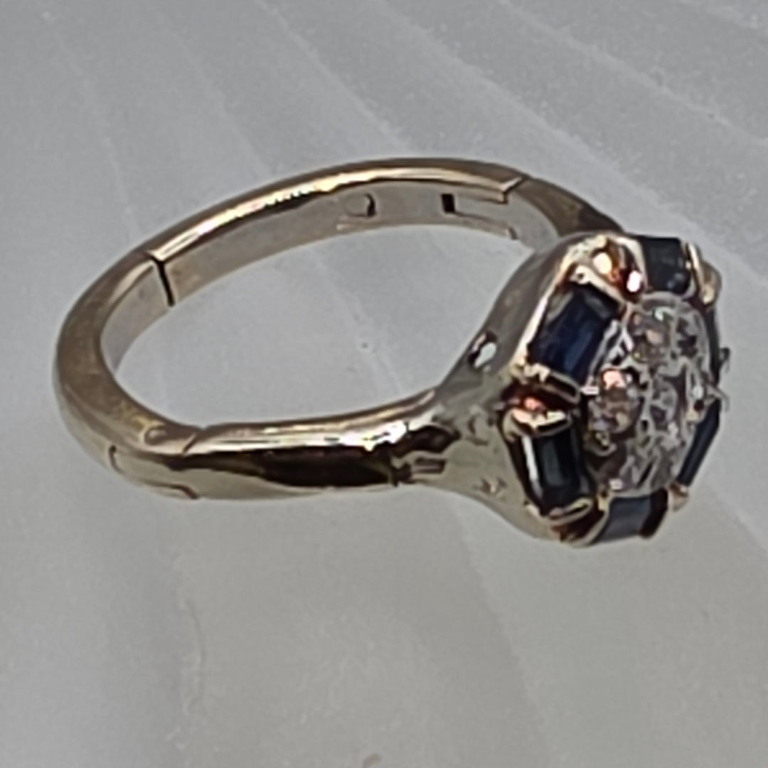 Gold ring with gemstones on a light gray background