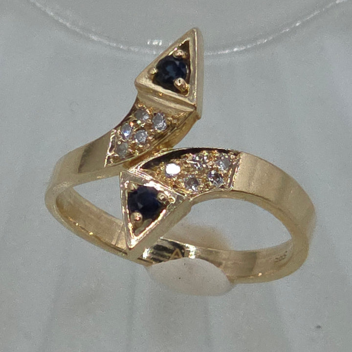 Gold ring with blue gemstones on a white background