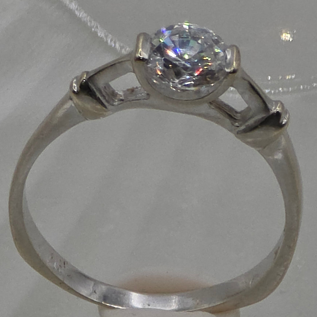 Silver ring with a diamond on a textured white background