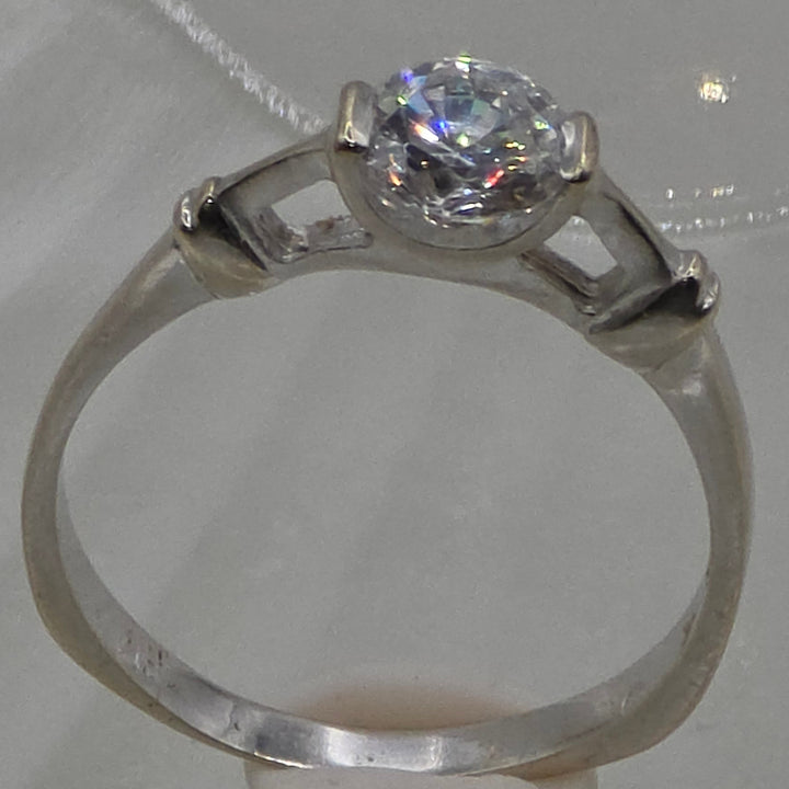 Silver ring with a diamond on a textured white background