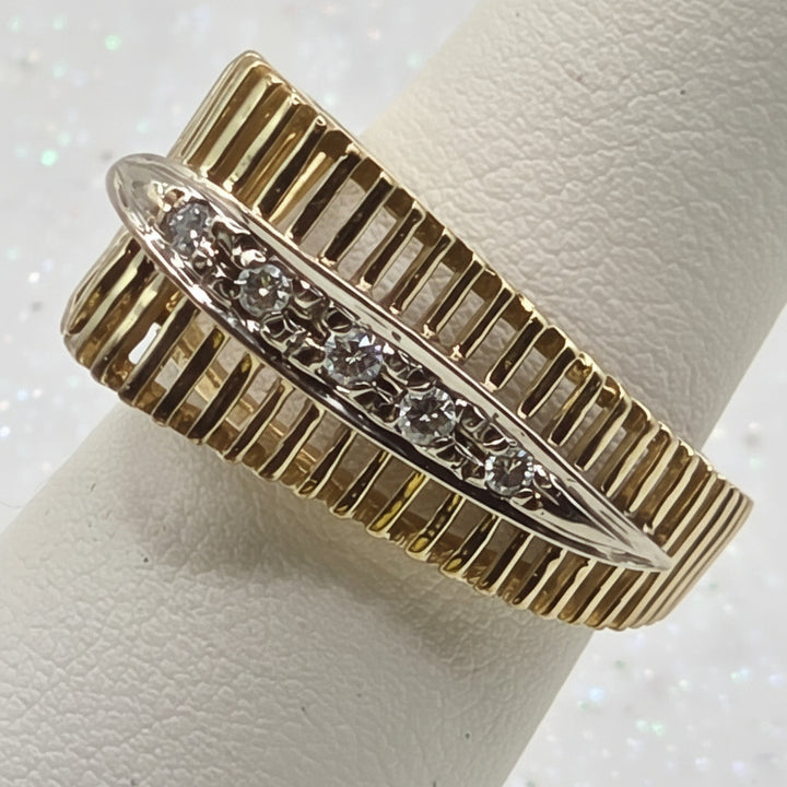 Gold ring with diamond accents on a light background