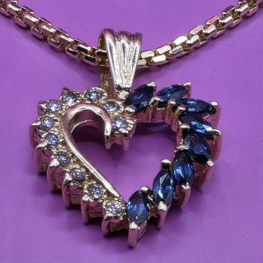 Gold necklace with a gold diamond and sapphire heart pendant