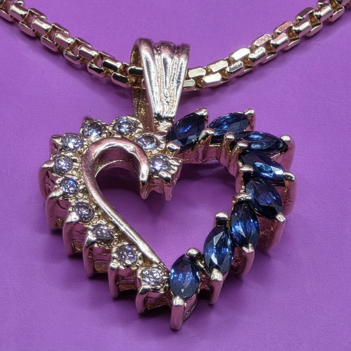 Gold necklace with a gold diamond and sapphire heart pendant