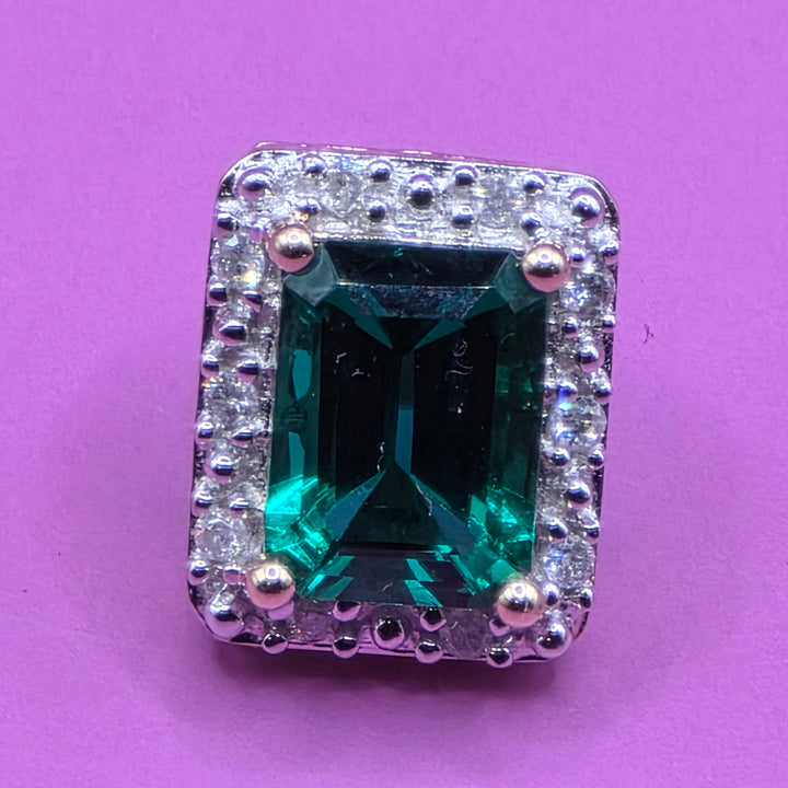 Green emerald gemstone stud earring with diamond-studded surround