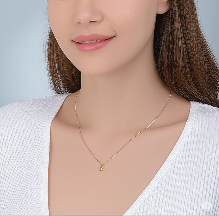 Gold necklace worn by a model against a neutral background