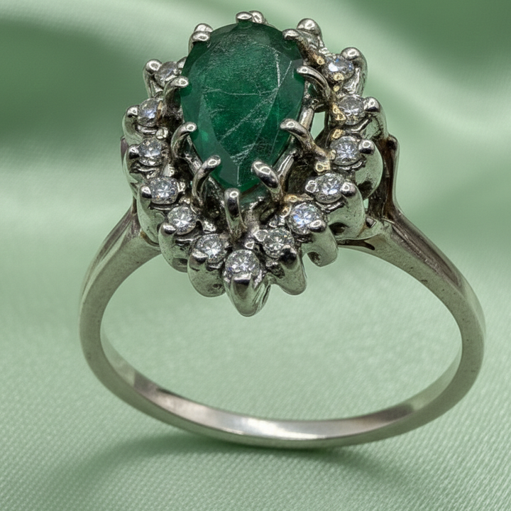 Gold ring with a green emerald surrounded with smaller diamonds