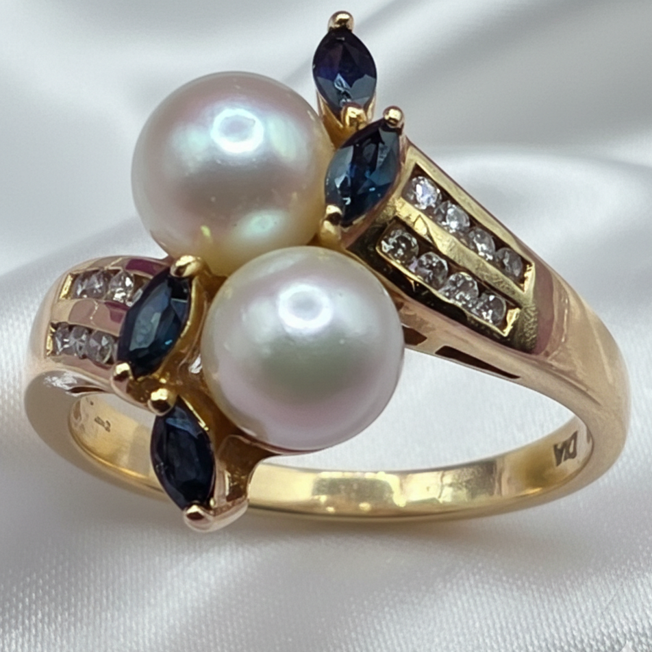 Gold ring with pearls, diamonds and sapphire gemstones on a white satin background