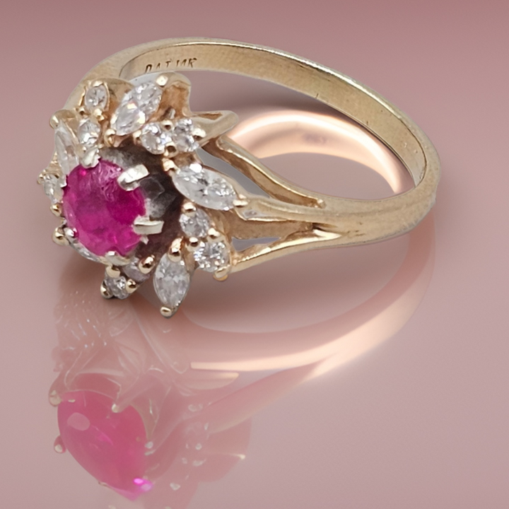 Gold ring with a pink gemstone and diamond accents on a pink background
