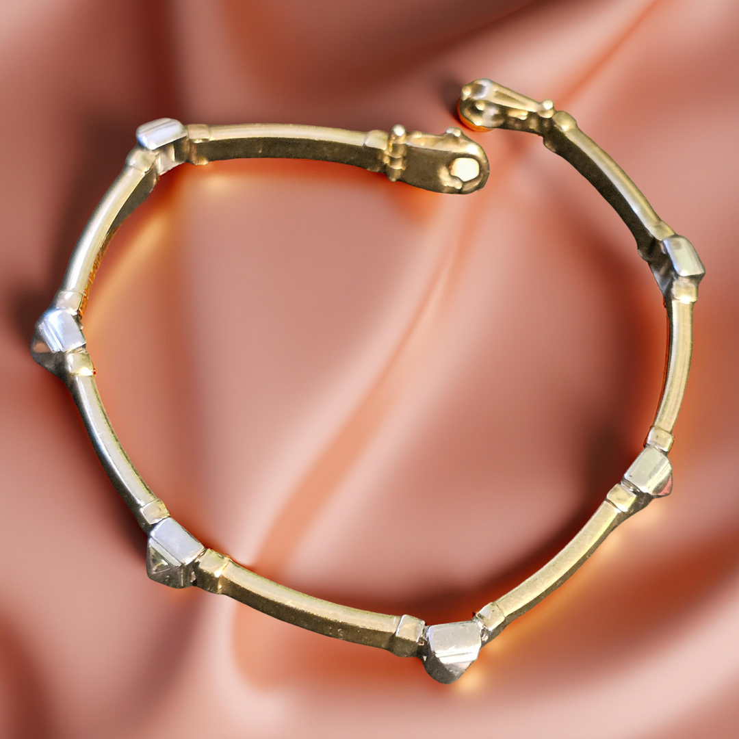 Gold bracelet with geometric design on a soft pink background