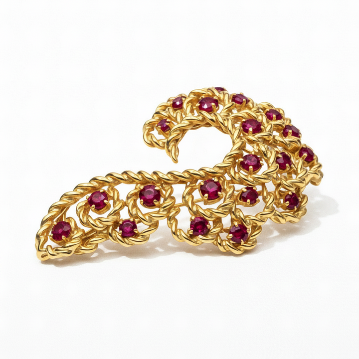 14k gold Serpentine brooch with ruby gemstones on a purple background